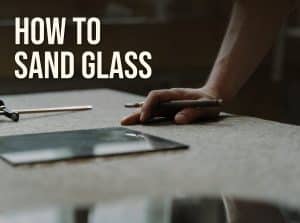 How to sand glass: a sheet of glass and a glass cutter on a felt-covered workbench