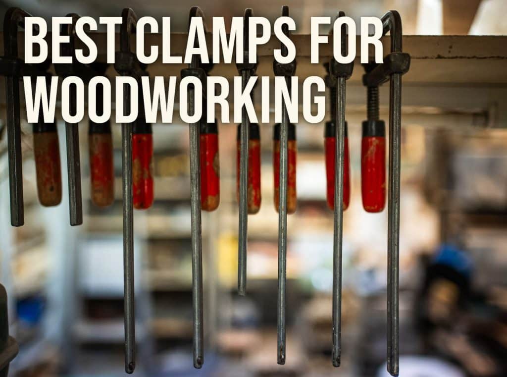 Best clamps for woodworking: F-style bar clamps hanging on a shop rack