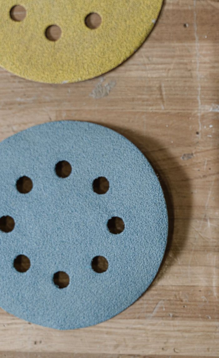 Two hook and loop sanding discs with an 8-hole dust pattern