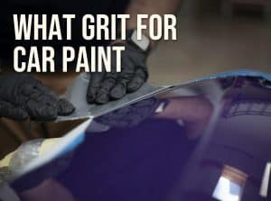 What grit sandpaper for car paint: wet sanding a dark car panel with a sheet of fine sandpaper