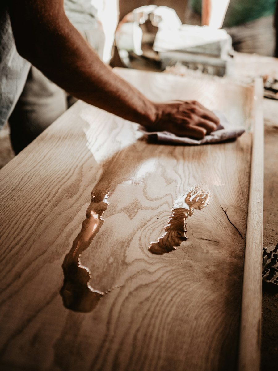Wiping down a bare oak board with a cloth after removing the old finish