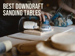 Best downdraft sanding table: a woodworker sanding a board with a random orbital sander on a shop bench