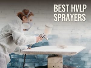 Best HVLP sprayer: a finisher in a respirator spraying a furniture panel with a gravity-feed HVLP spray gun