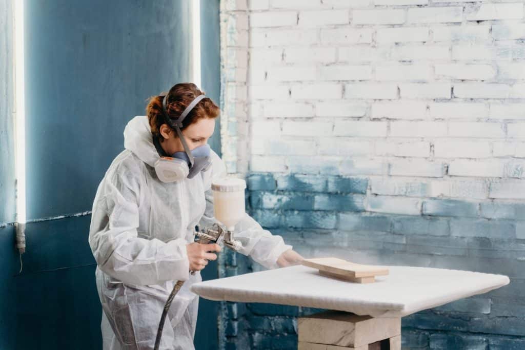 Spraying a small wooden board flat on a stand to avoid runs